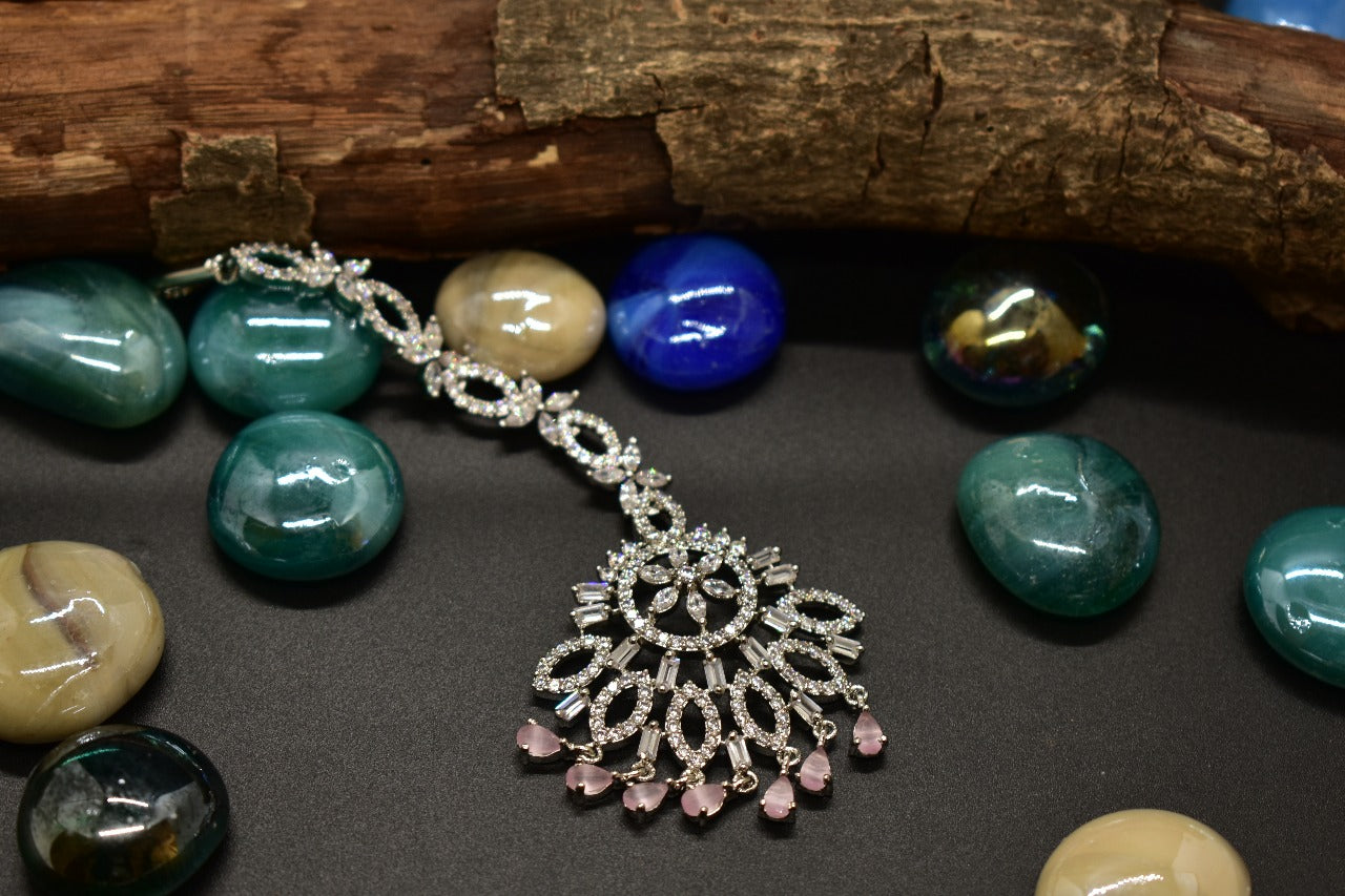 AD flower Mang tikka with pink AD drops on a black background with colourful stones around