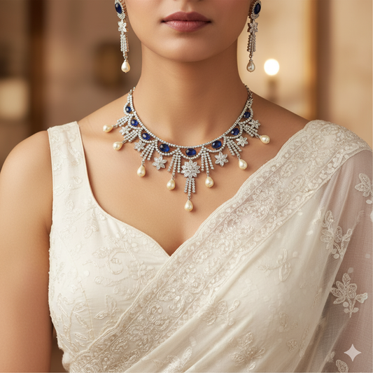 Woman wearing a white saree with a detailed necklace and earrings.