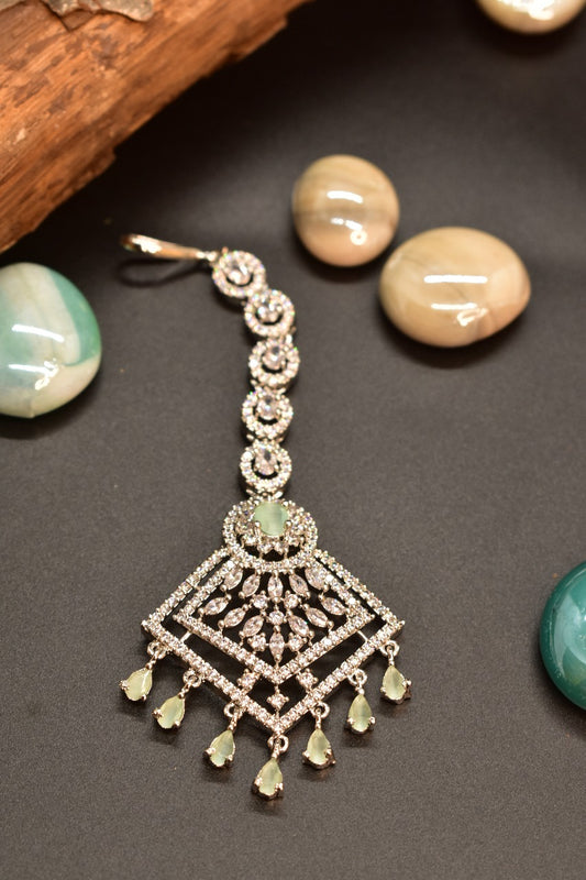 AD Mang tikka with mint green gemstone  and AD drops on a dark background