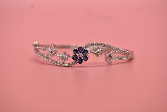 American Diamond Silver bracelet with a blue flower charm on a pink background