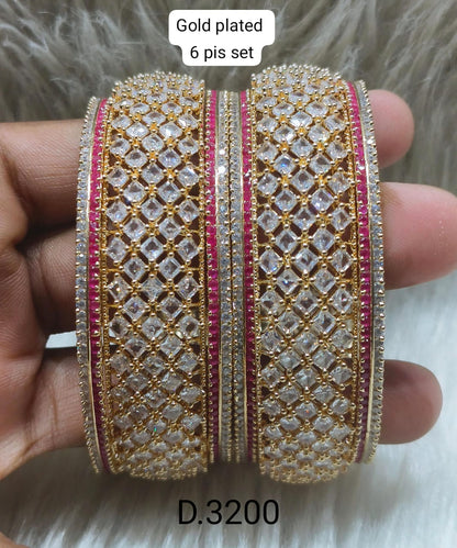 AD Gold-plated bangles with red diamond-like stones.